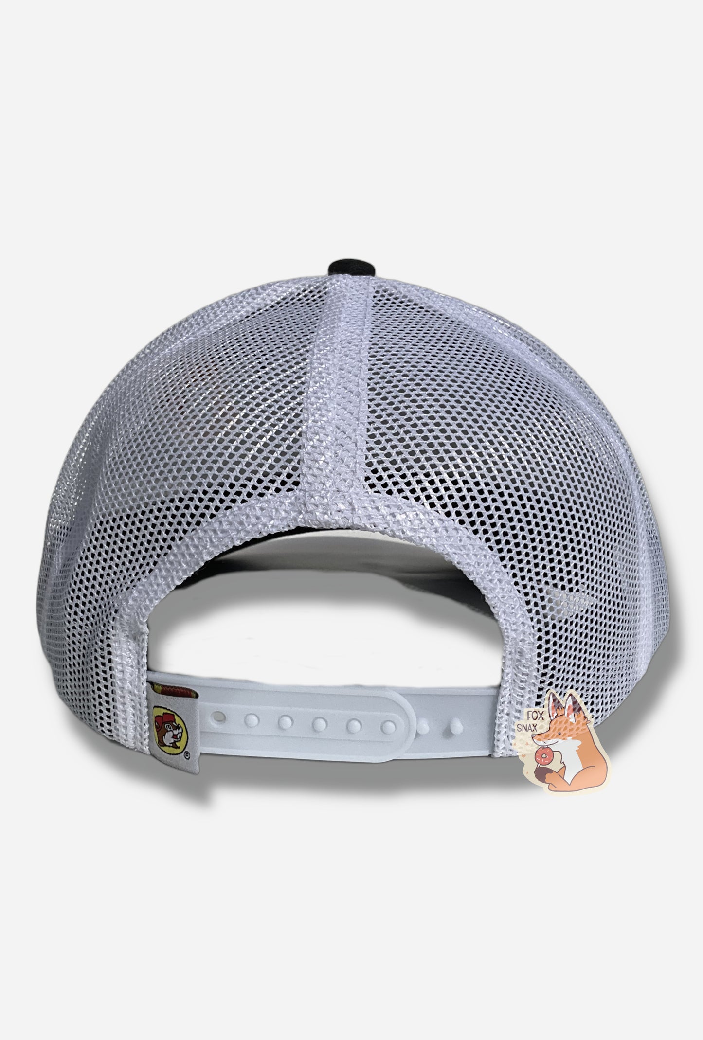 A picture of the back of a  red, white, and blue ball cap/ The back and sides of the cap are a white plastic mesh.  The cap has a small square tag with the Buc-ee's logo: a brown-furred beaver with a significant overbite, wearing a red ball cap.