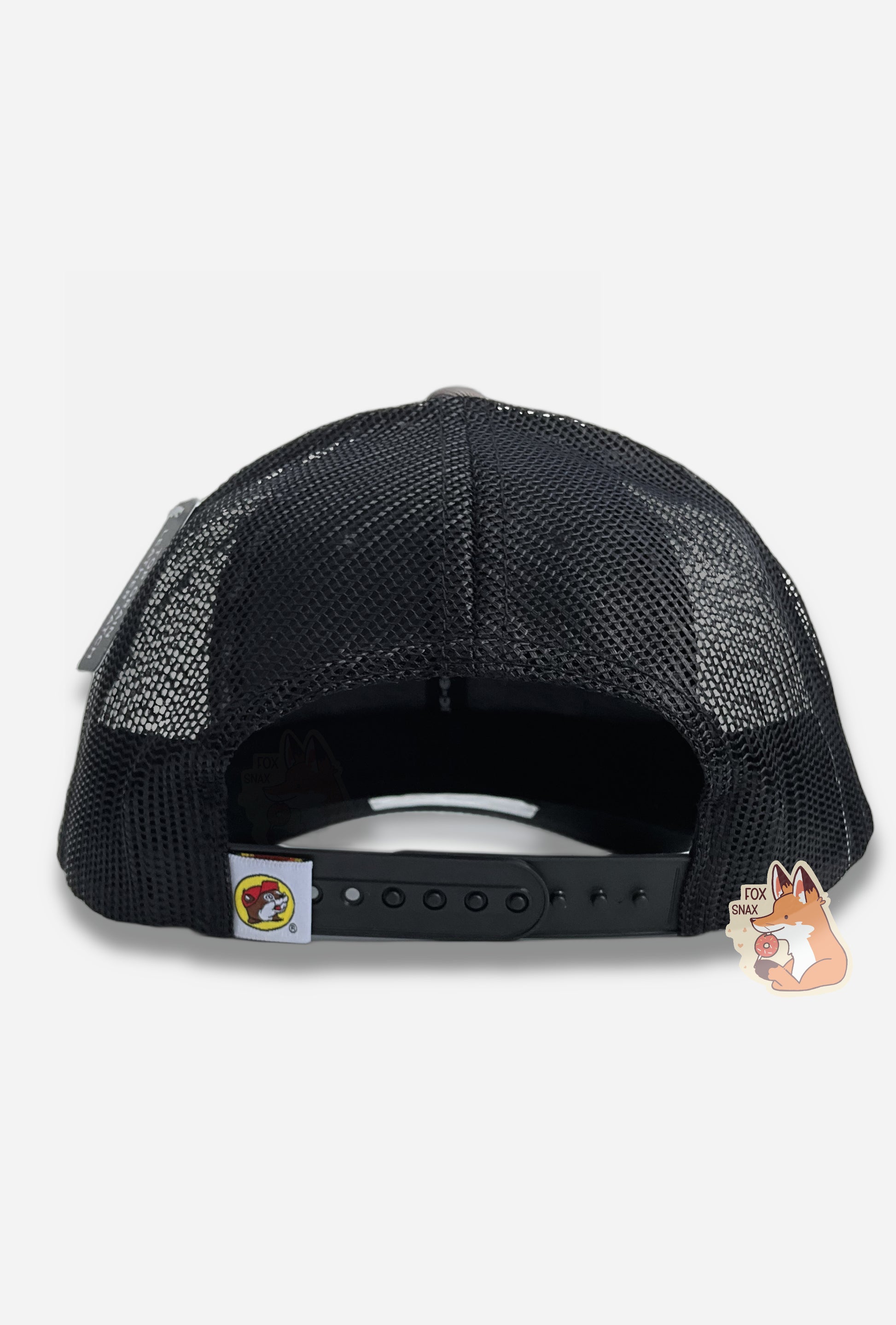 A picture of the back of a grey and black ball cap.  The back and sides of the cap are a black plastic mesh.  A very small square tag on the back of the cap has the Buc-ee's logo: a brown furred beaver with a significant overbite, wearing a red ball cap.