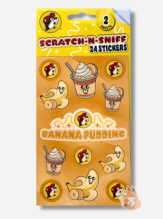 A rectangular package of Buc-ee's Scratch-N-Sniff Banana Pudding stickers.  The stickers on the package are the Buc-ee's logo - a brown-furred beaver with a massive overbite, a tub of banana pudding with a beaver grin on its body, cut up bananas with a similar beaver grin on the fruit side (it's all a bit surreal), and in the middle, a Buc-ee's logo with the words BANANA PUDDING.  The top of the package reads 2 SHEETS, then SCRATCH-N-SNIFF, 24 STICKERS