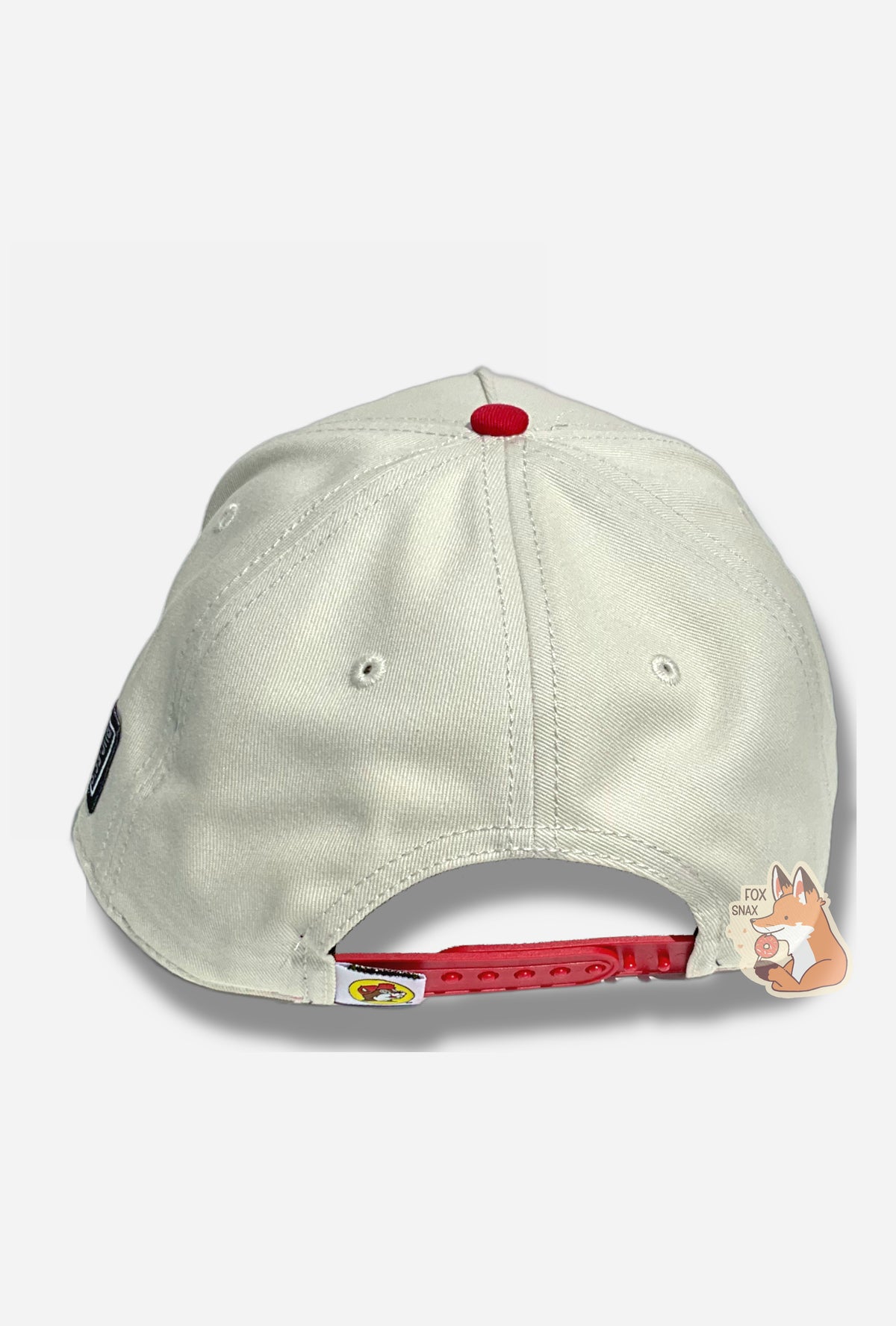 A picture of the back of a red and white baseball cap.  The body of the cap is white.  The button on top of the cap and the snapback on top of the cap.  The back and sides of the cap are a white cloth.