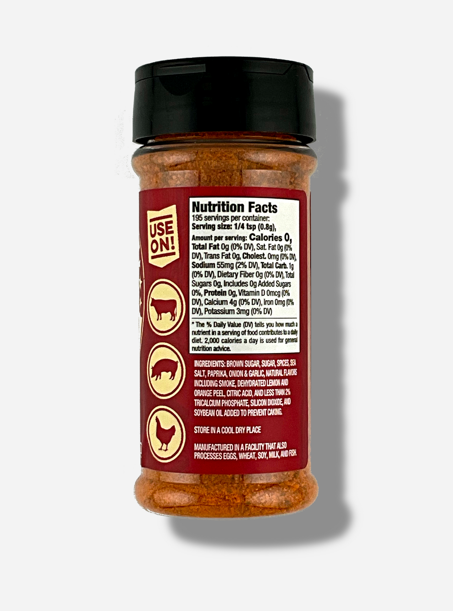 A picture of the back of a container of Texas Round Up BBQ Rub.  The container has a black plastic flip lid, and a clear plastic body.  The spices inside appear red/orange and black.  The red label reads USE ON!, and beneath that, there is an outline of a cow, a pig, and a chicken.