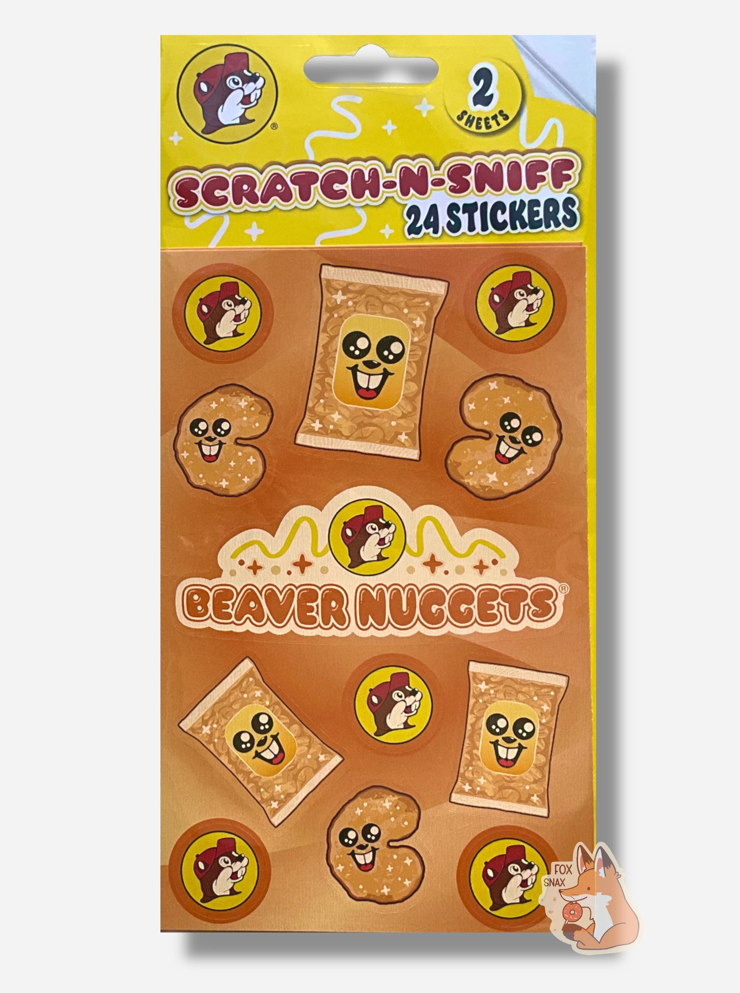 A rectangular package of Buc-ee's Scratch-N-Sniff Beaver Nuggets stickers.  The stickers on the package are the Buc-ee's logo - a brown-furred beaver with a massive overbite, a singular beaver nugget with a beaver grin on its body, package of beaver nuggets with a similar beaver grin (it's all a bit surreal), and in the middle, a Buc-ee's logo with the words BEAVER NUGGETS.  The top of the package reads 2 SHEETS, then SCRATCH-N-SNIFF, 24 STICKERS