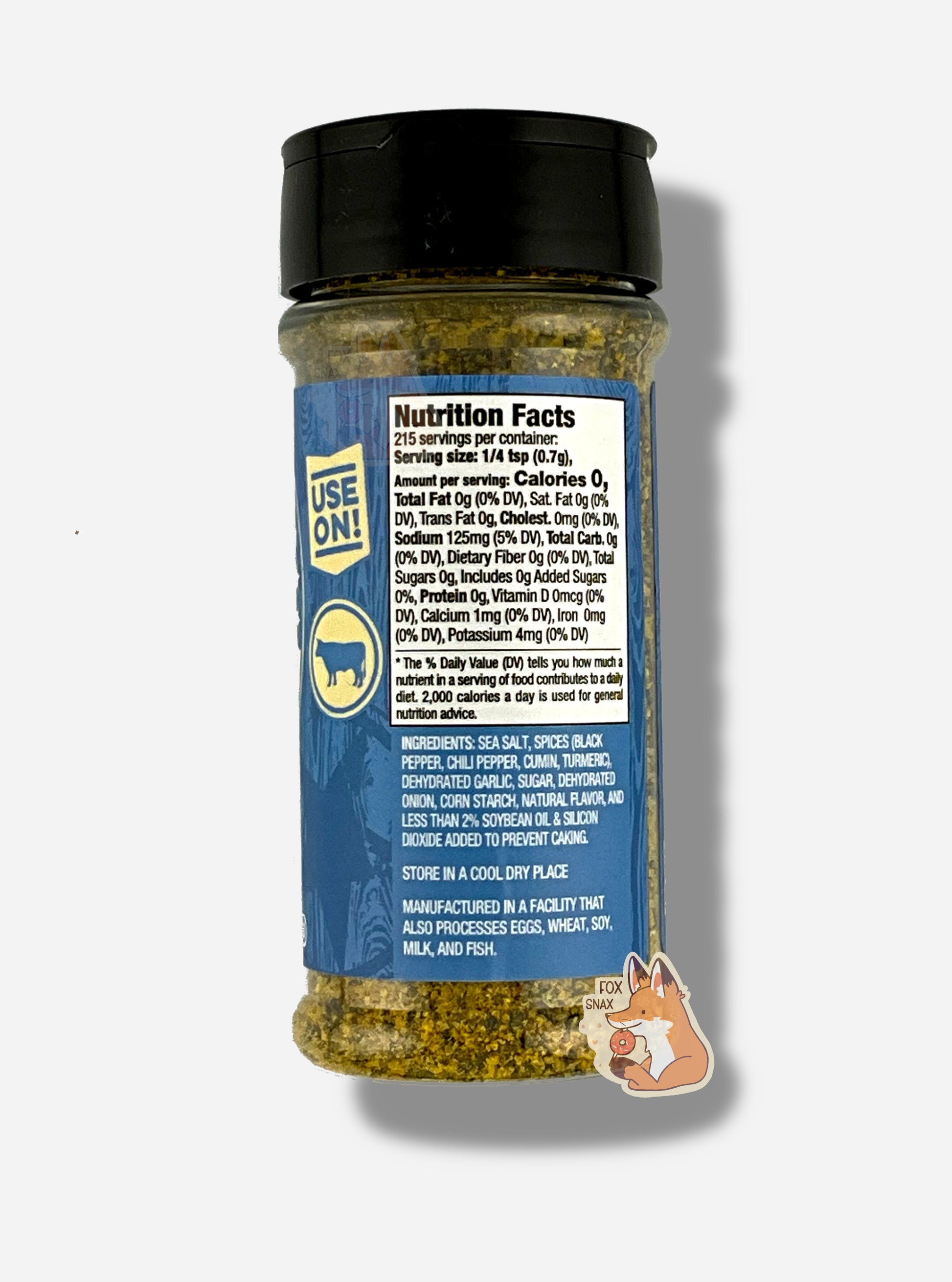 A picture of the back of a container of Texas Round Up Brisket Rub.  The container has a black plastic flip lid, and a clear plastic body.  The spices inside appear grey and black.  The blue label reads USE ON!, and beneath that, there is an outline of a cow.