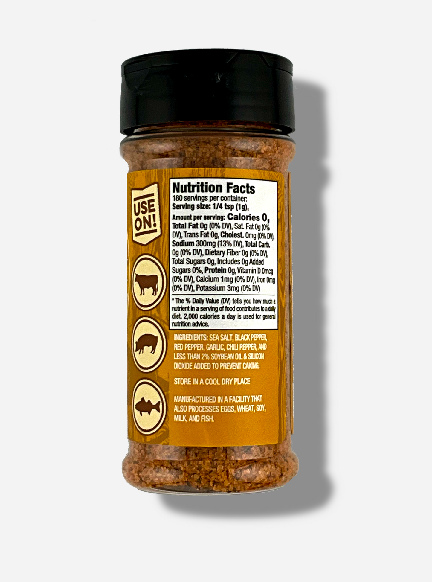 A picture of the back of a container of Texas Round Up Cajun Seasoning. The container has a black plastic flip lid, and a clear plastic body.  The spices inside appear orange and grey. The tan label reads USE ON!, and beneath that, there is an outline of a cow, a pig, and a chicken.