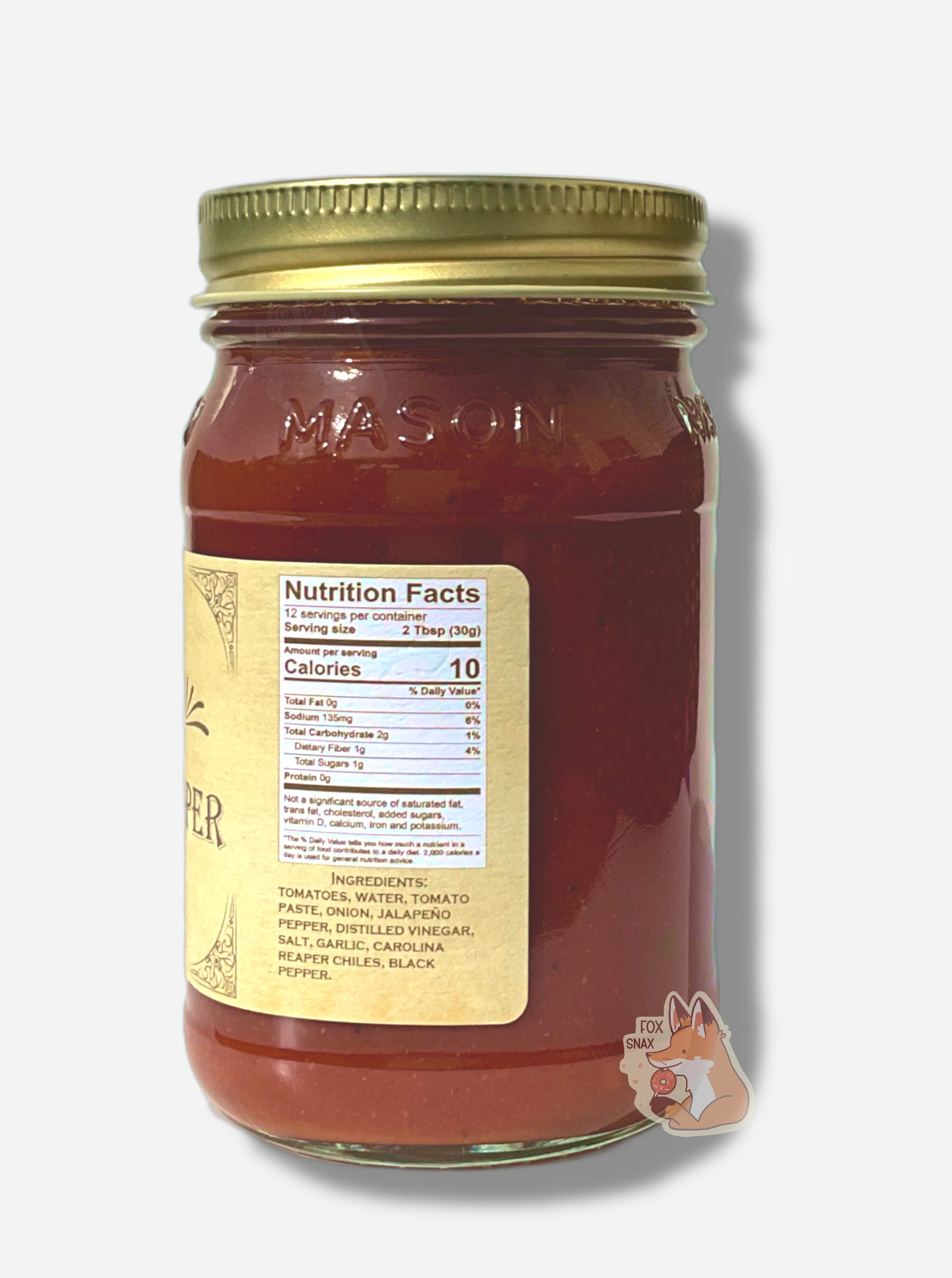 A picture of the right side of a glass jar of Buc-ee's Mango Pineapple Habanero -  the label is a "old-timey" sort of white/yellow with flared edges.  The middle reads Ingredients: Tomatoes, Water, Tomato Paste, Onion, Jalapeno Pepper, Distilled Vinegar, Salt, Garlic, Carolina Reaper Chiles, Black Pepper.