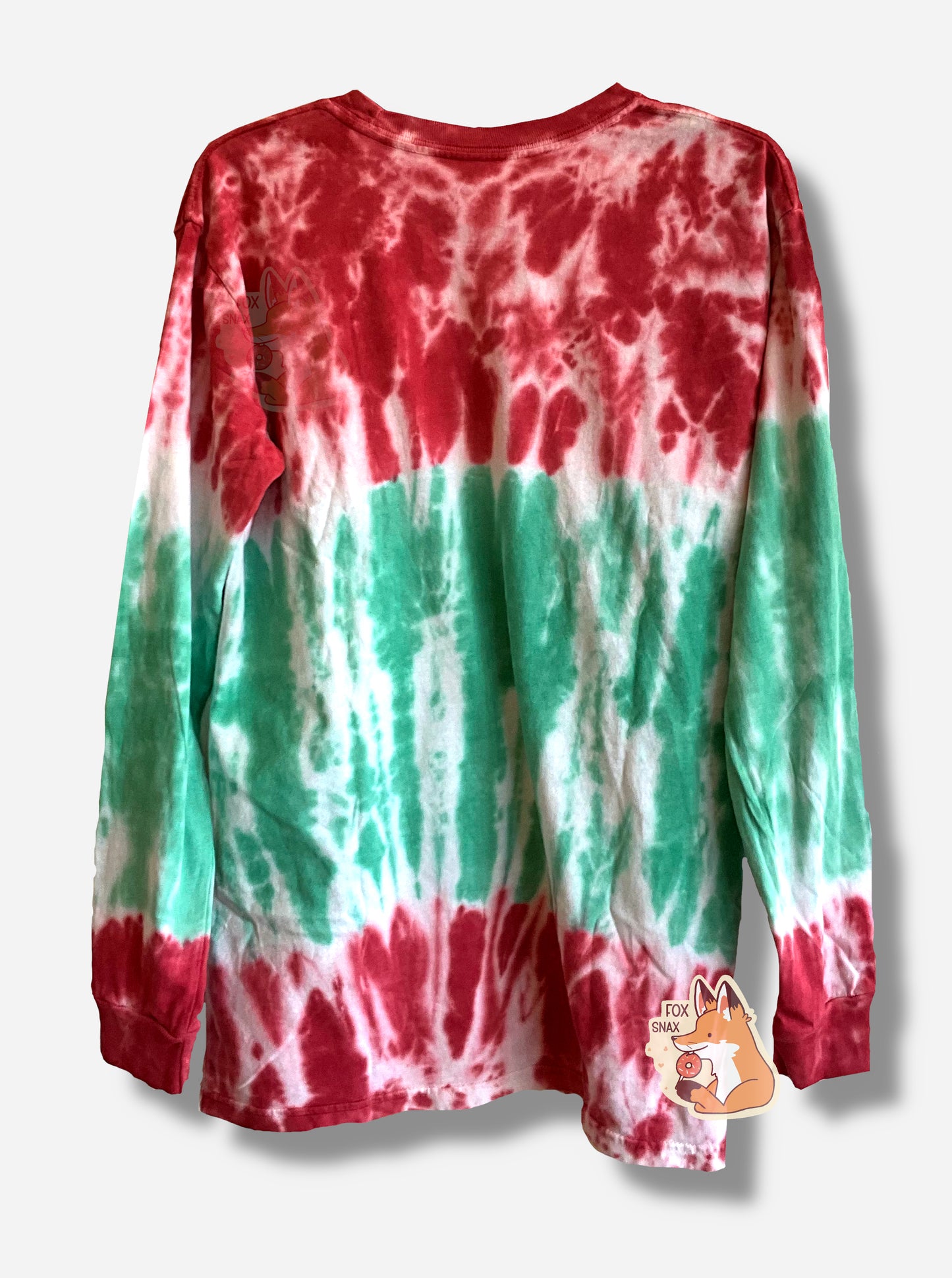 A picture of the back of a red, white, and green Christmas tie-dye long sleeve shirt.  The top of the shirt - sleeves, upper chest - is mostly red, with some white streaks.  A small band of uneven white is around the upper/middle chest, which fades down into green at the bottom around the belly.  The bottom of the shirt shows another brief band of white, then red.