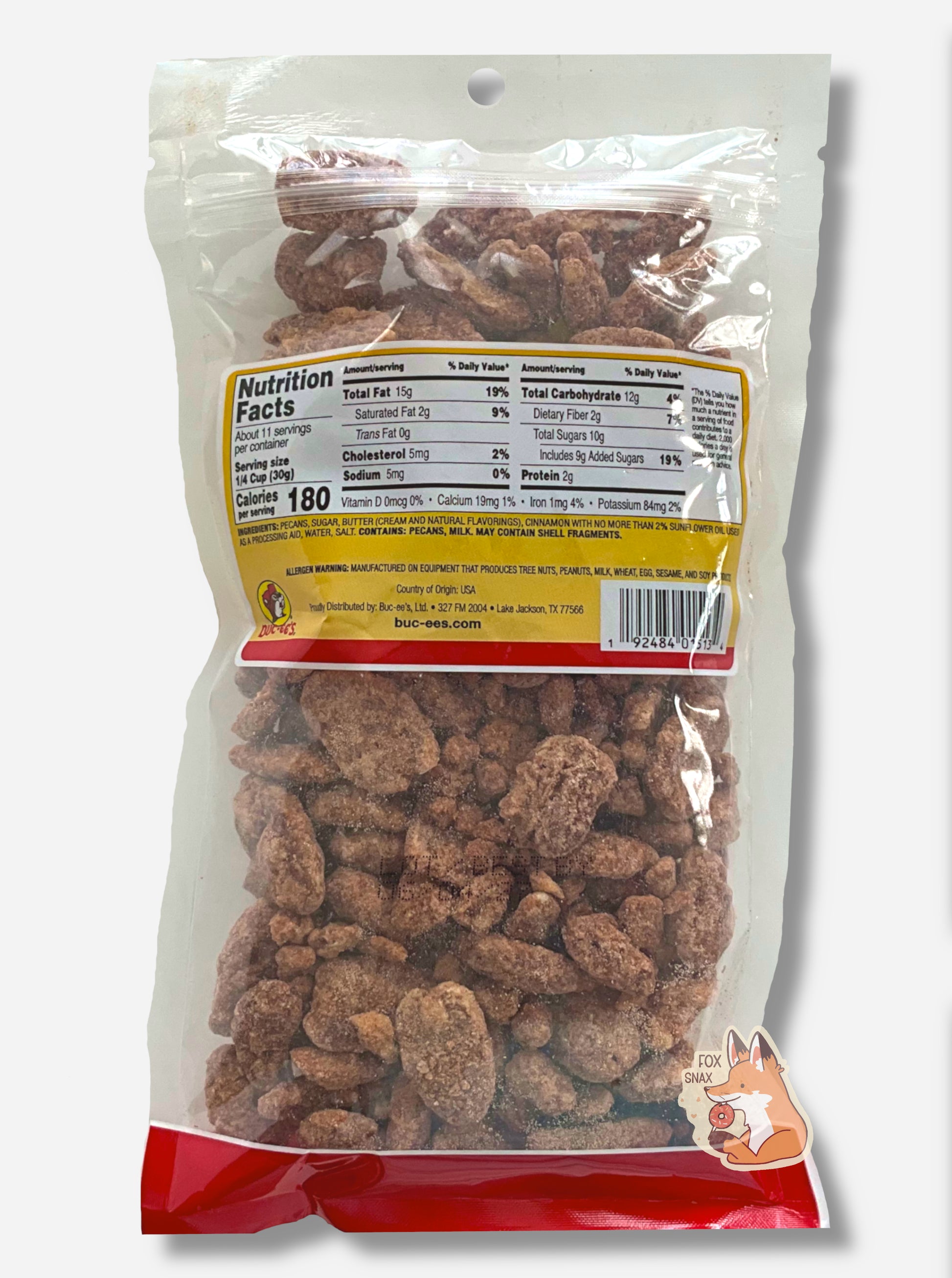 A picture of the back of a clear plastic bag of Buc-ee's Cinnamon Pecans.  Inside the bag are a large number of dried pecans, covered in brownish, reddish sugary cinnamon coating.