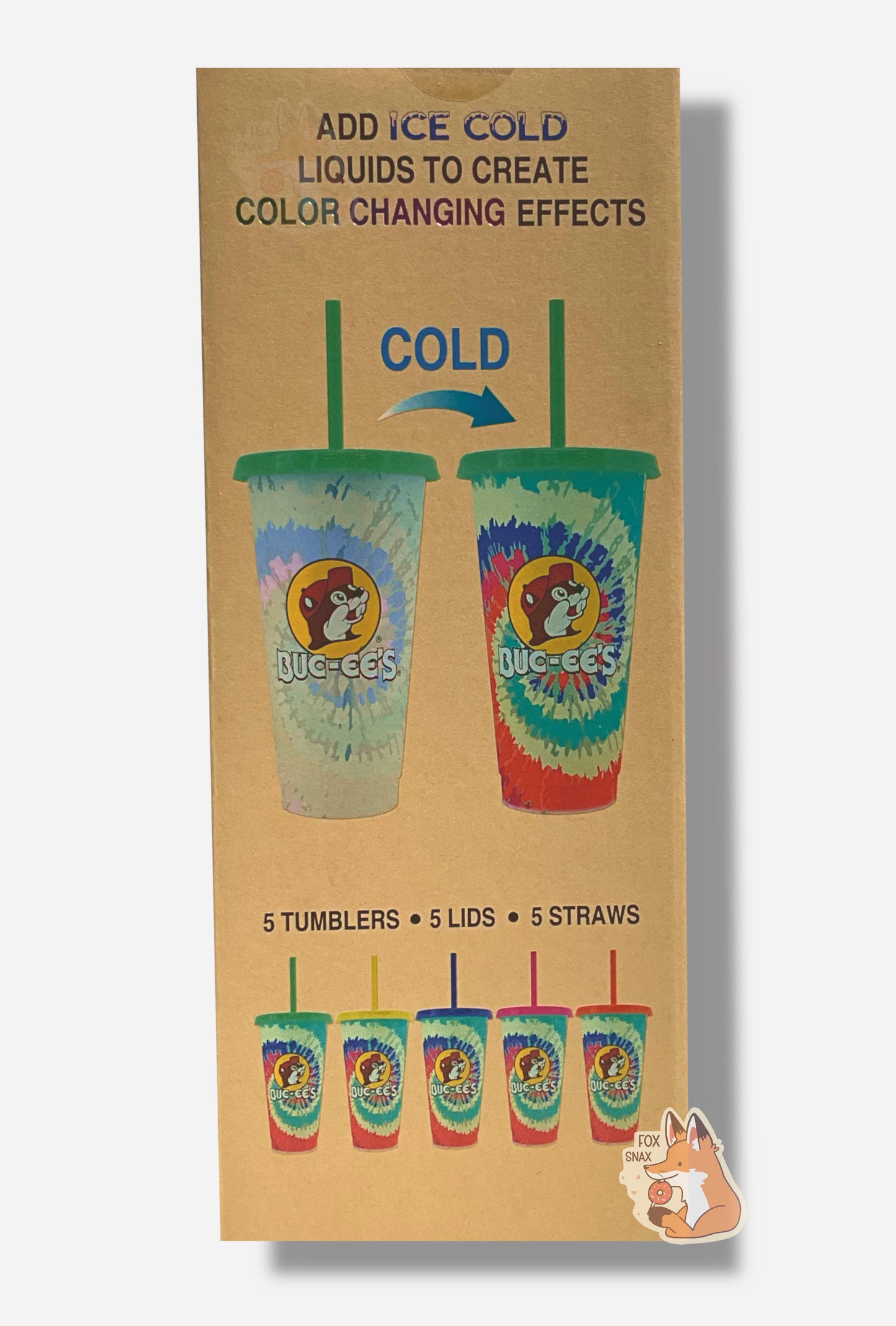 A picture of a tall, thin cardboard box.  The top of the box reads ADD ICE COLD LIQUIDS TO CREATE COLOR CHANGING EFFECTS.  A faded, white-ish tumbler is shown in the middle left, a "COLD ->" arrow on top, and on the right, the same tumbler, but with a bright, vibrant tie-dye set of colors: blue, red, white, and cyan in a spiral.  The bottom of the box reads 5 TUMBLERS, 5 LIDS, 5 STRAWS.