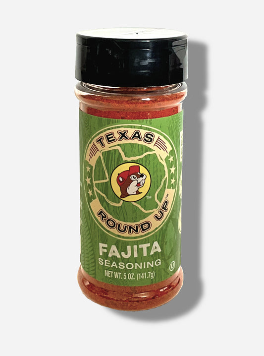 A picture of the front of a container of Texas Round Up Fajita Seasoning.  The container has a black plastic flip lid, and a clear plastic body.  The spices inside appear red/orange.  The label reads TEXAS ROUND UP, with an outline of the state of Texas, with a picture of Buc-ee The Beaver in the middle.  Beneath that, the tan label reads in white text, Fajita Seasoning.  Net Wt 5 Oz (141.7 g).