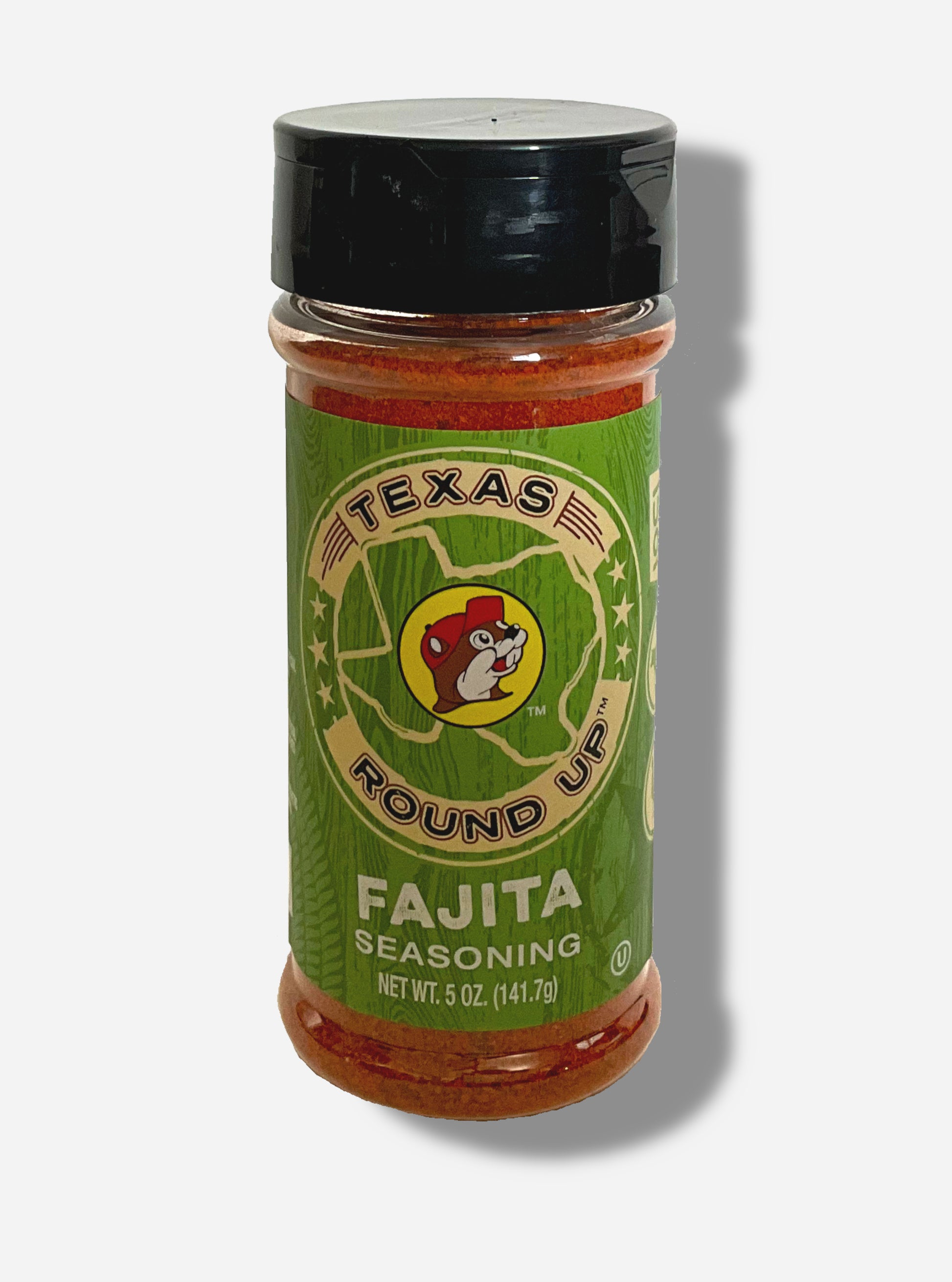 A picture of the front of a container of Texas Round Up Fajita Seasoning.  The container has a black plastic flip lid, and a clear plastic body.  The spices inside appear red/orange.  The label reads TEXAS ROUND UP, with an outline of the state of Texas, with a picture of Buc-ee The Beaver in the middle.  Beneath that, the tan label reads in white text, Fajita Seasoning.  Net Wt 5 Oz (141.7 g).