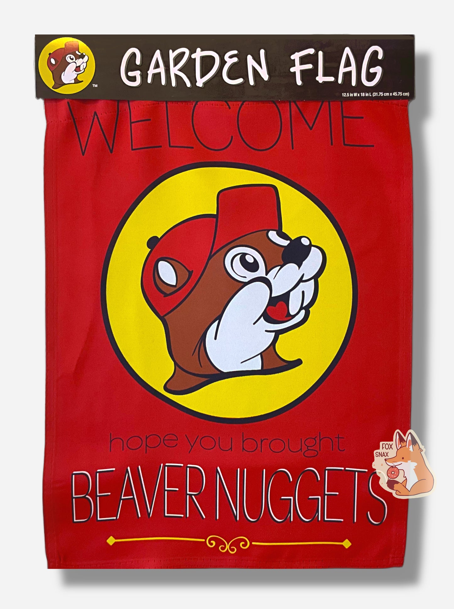A picture of a pretty red garden flag.  The front of the flag has a  Buc-ee's logo dead in the center - a cheerful beaver with an overbite, wearing a red cap, framed by a yellow circle.  The top of the flag reads WELCOME in thin uppercase black text.  The bottom of the flag reads "hope you brought" in lowercase black text, then "BEAVER NUGGETS" in white/black uppercase text.  The top of the flag has a bit of paper on it, part of the wrapping (not flag), that reads GARDEN FLAG/