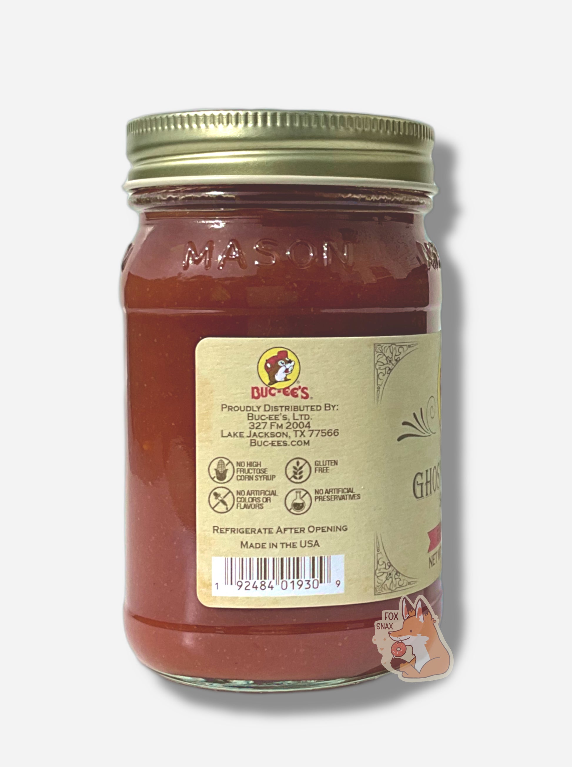 A picture of the left side of a glass jar of Buc-ee's Ghost Pepper Salsa - the label is a "old-timey" sort of white/yellow with flared edges.  The middle reads No High Fructose Corn Syrup, No Artificial Colors Or Flavors, Gluten Free, No Artificial Preservatives. In the jar, reddish salsa can be seen.