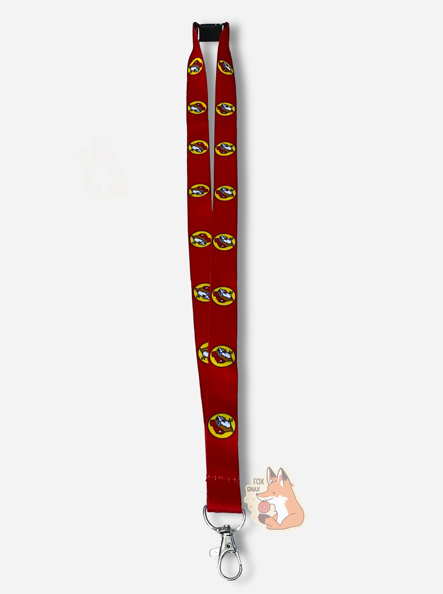 A picture of a small red lanyard.  The lanyard has a metal snap on one end, and a black plastic buckle on the other.  The material that connects them is a smooth-looking red ribbon.  The ribbon is printed with the Buc-ee's logo: a cheerful beaver wearing a red ball cap.  In this picture, the lanyard is buckled, making a loop to fit over one's neck.