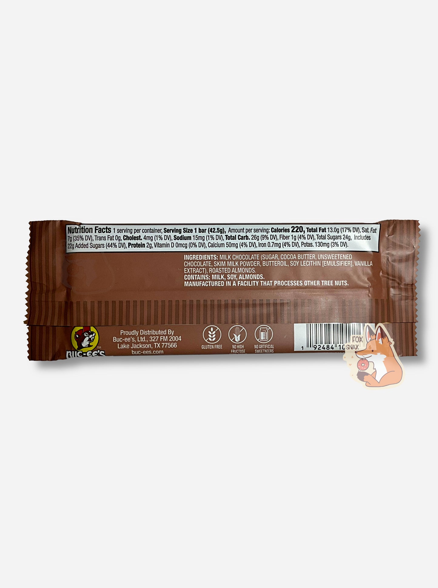 A picture of the back of a rectangular bar of a Buc-ee Bar.  The label is brown, and at the bottom, it reads GLUTEN FREE, NO HIGH FRUCTOSE CORN SYRUP, NO ARTIFICIAL SWEETENERS.