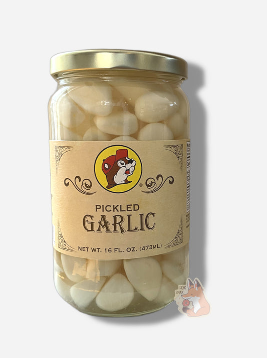 A picture of the front of a glass jar of Buc-ee's Pickled Garlic - the label is a "old-timey" sort of white/yellow with flared edges.  The middle has a giant Buc-ee the Beaver logo on it.  In the jar, floating garlic cloves in an clear brine can be seen.