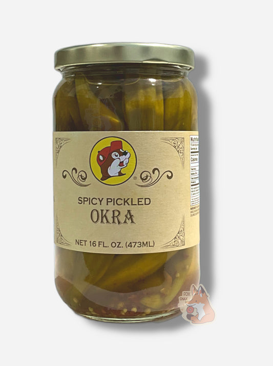 A picture of the front of a glass jar of Buc-ee's Spicy Pickled Okra  - the label is a "old-timey" sort of white/yellow with flared edges.  The middle has a giant Buc-ee the Beaver logo on it.  In the jar, long okra and a red pepper bits in a mostly clear brine can be seen.
