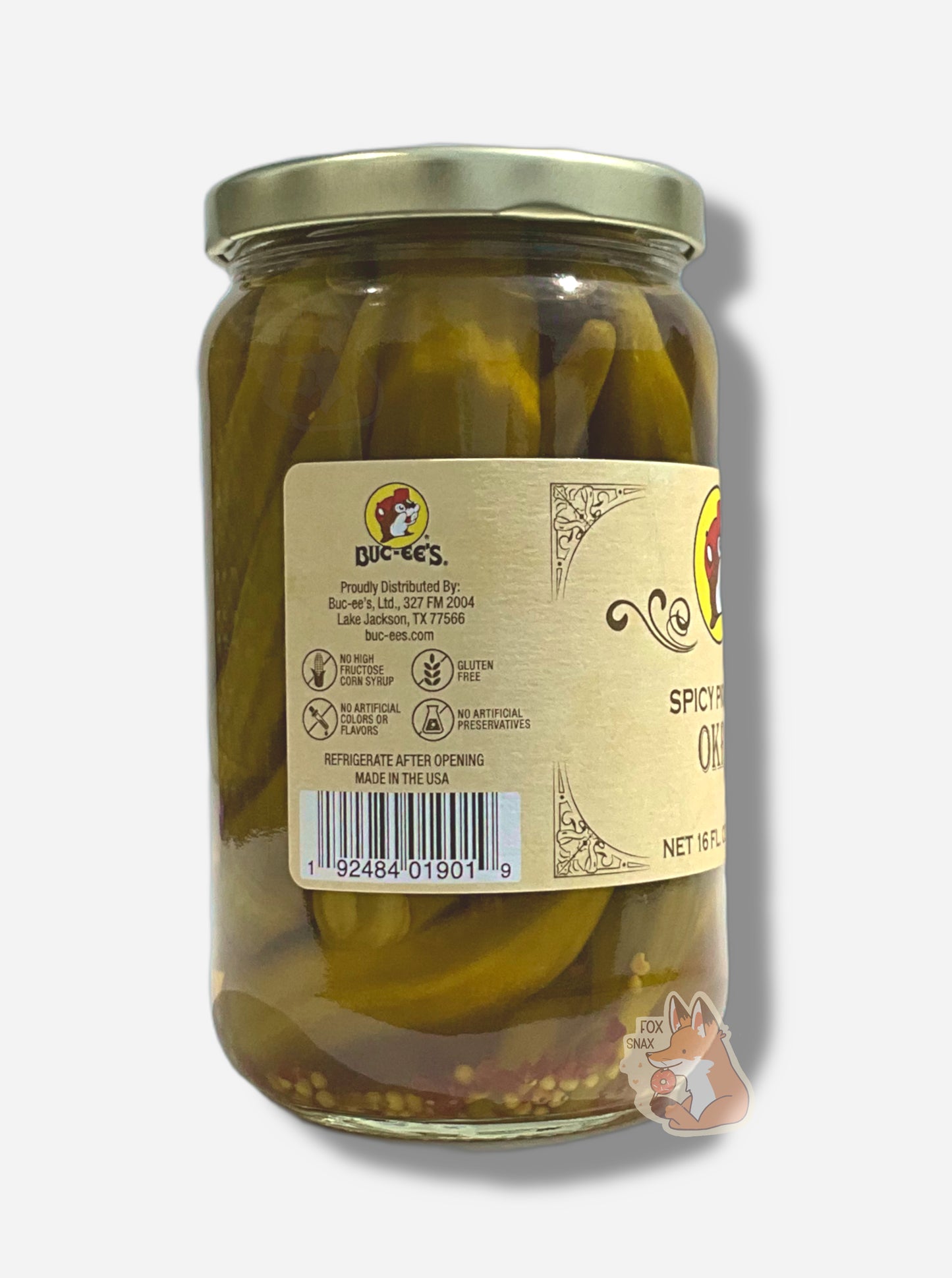 A picture of the left side of a glass jar of Buc-ee's Spicy Pickled Okra - the label is a "old-timey" sort of white/yellow with flared edges.  The middle reads No High Fructose Corn Syrup, No Artificial Colors Or Flavors, Gluten Free, No Artificial Preservatives.  In the jar, long okra floating in clear brine with bits of red pepper can be seen.