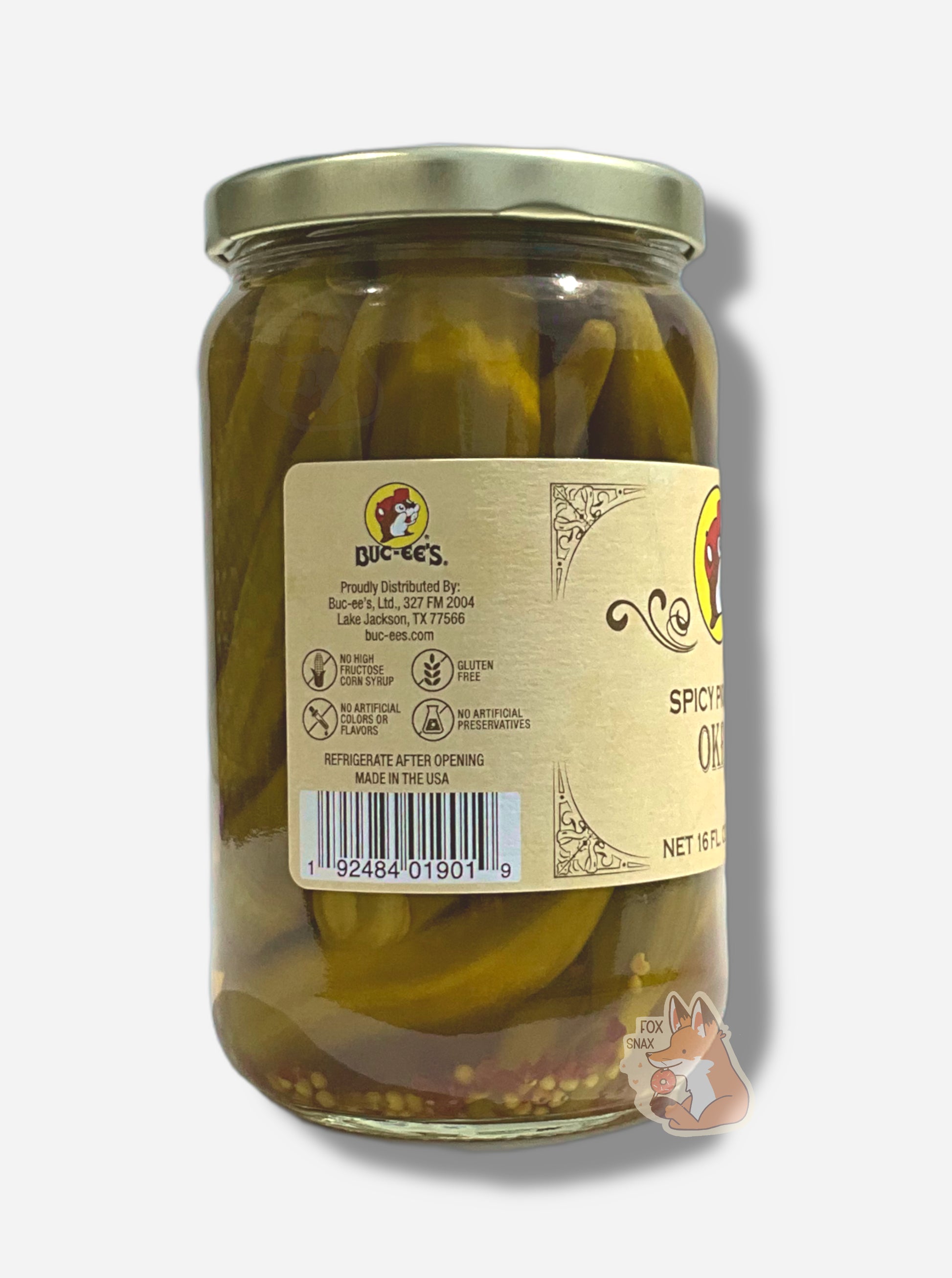 A picture of the left side of a glass jar of Buc-ee's Spicy Pickled Okra - the label is a "old-timey" sort of white/yellow with flared edges.  The middle reads No High Fructose Corn Syrup, No Artificial Colors Or Flavors, Gluten Free, No Artificial Preservatives.  In the jar, long okra floating in clear brine with bits of red pepper can be seen.