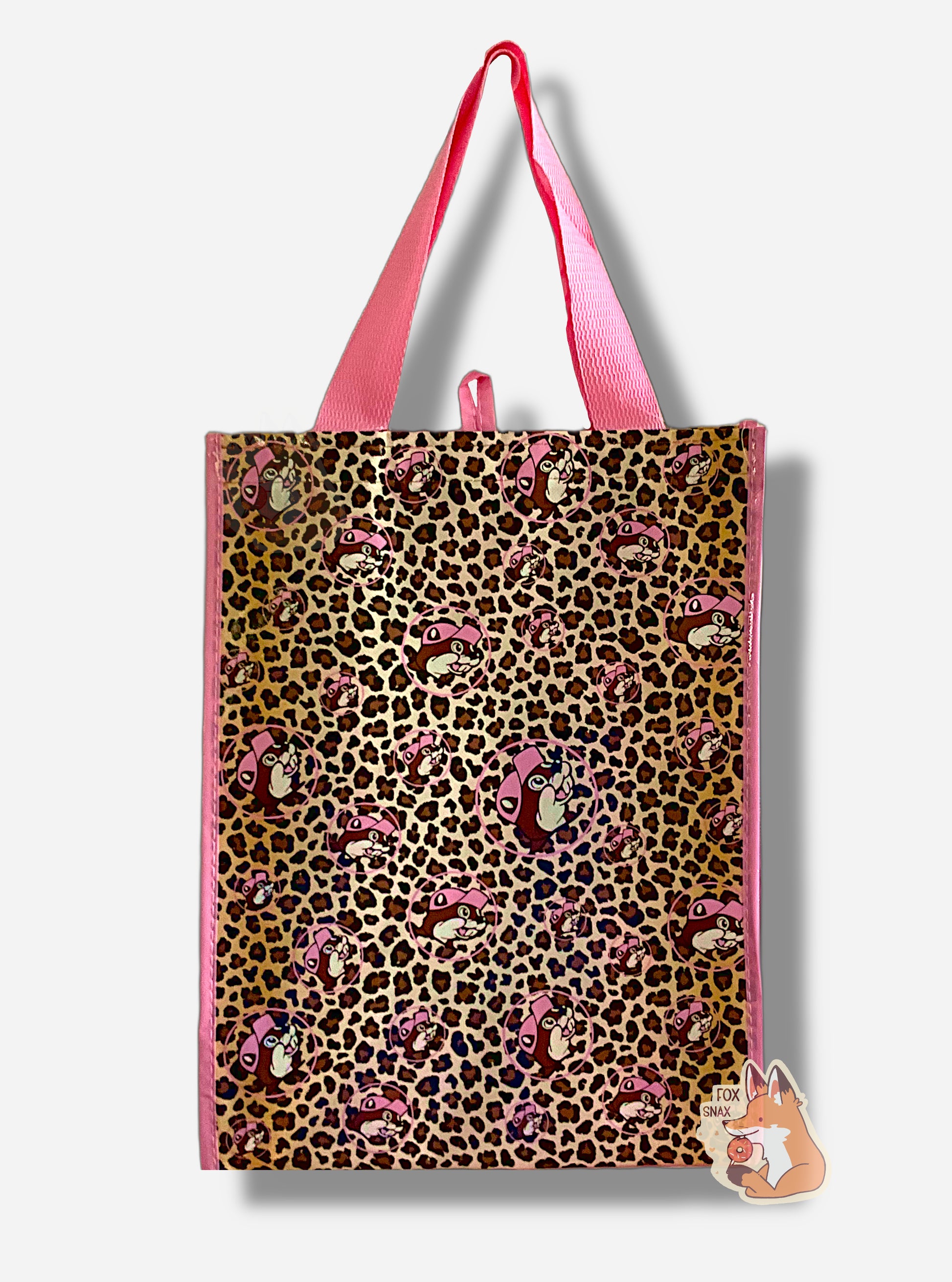 A picture of the back of a large rectangular pink plastic shopping bag.  The entirety of the bag is covered in brown leopard spots and Buc-ee The Beaver logos in different sizes and orientations.  The bag itself reads BUC-EES in pink text.  The strap on the bag is made of pink cloth.  The vertical edges of the bag have a thin pink stripe.