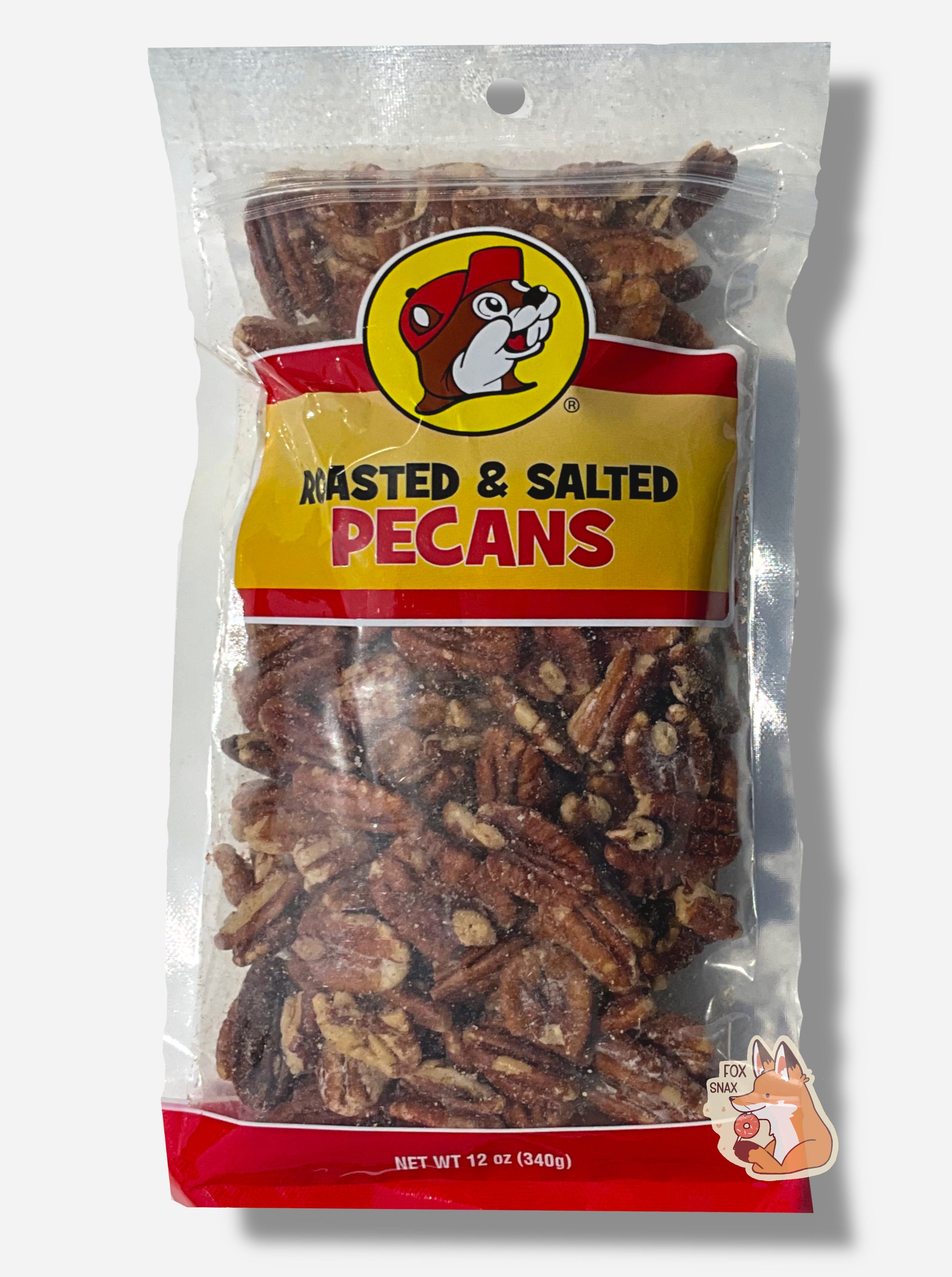 A picture of a clear plastic bag of Buc-ee's Roasted & Salted Pecans.  The Buc-ee's logo can be seen in the top center of the bag, then underneath that in black and red text, ROASTED & SALTED PECANS.  The bottom of the bag is red and reads Net Wt 12 oz.  Inside the bag are a large number of dark brown  pecans; some grains of salt are on the pecans.
