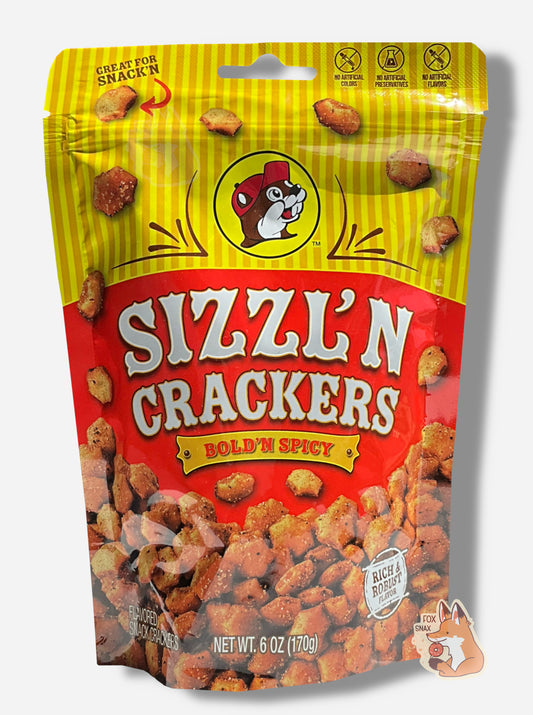 A picture of a metallic bag of Buc-ee's Sizzl'n Crackers and Bold'N Spicy.  The logo is a dark red background on white text; a large number of reddish, savory-looking hexagonal oyster crackers are shown beneath it.  At the top is a picture of the logo of Buc-ee The Beaver, and it reads GREAT FOR SNACK'N, NO ARTIFICIAL COLORS, NO ARTIFICIAL PRESERVATIVES, NO ARTIFICIAL FLAVORS and RICH AND ROBUST FLAVOR