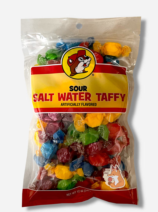 A picture of the front of a plastic bag of Buc-ee's Sour Salt Water Taffy.  The bag is clear plastic with the Buc-ee's logo.  Inside it, twists of candy in five different wrapping colors (red, yellow, green, purple) can be seen.  The front of the bag has the Buc-ee's logo - a brown-furred beaver with a significant overbite, wearing a red ball cap - and reads:  SOUR SALT WATER TAFFY, ARTIFICIALLY FLAVORED, then 12 OZ.