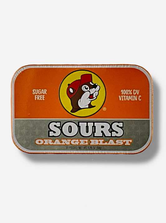 A picture of a tin of Buc-ees Orange Blast Sours. The cover is decorated with a big picture of Buc-ee The Beaver, and has an orange and silver background.  The tin reads Sugar Free, 100% DV Vitamin C, Sours, Orange Blast, 50 pieces.