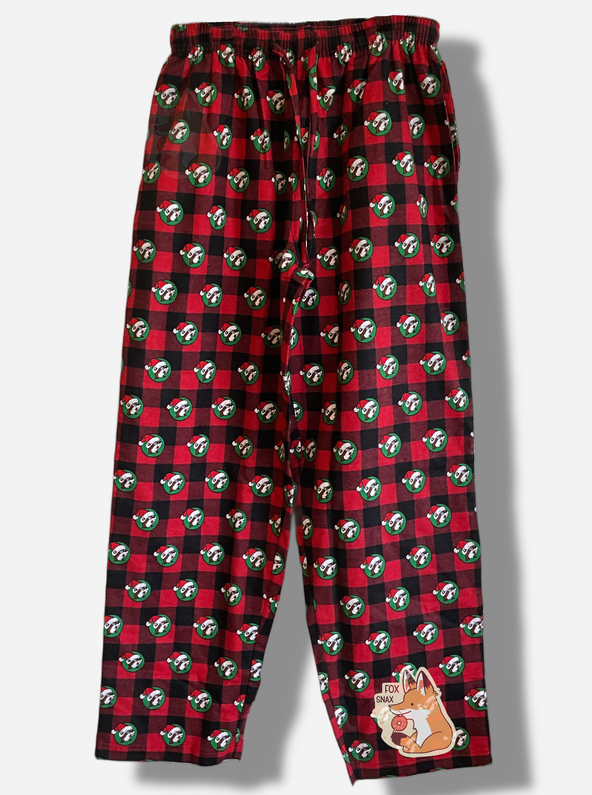 A picture of a black and red plaid pajama pants.  The pants are studded with the Buc-ee's logo - a brown furred beaver with a significant overbite - who is wearing a Santa cap against a green circular background.  The pants show an untied drawstring around the waist.