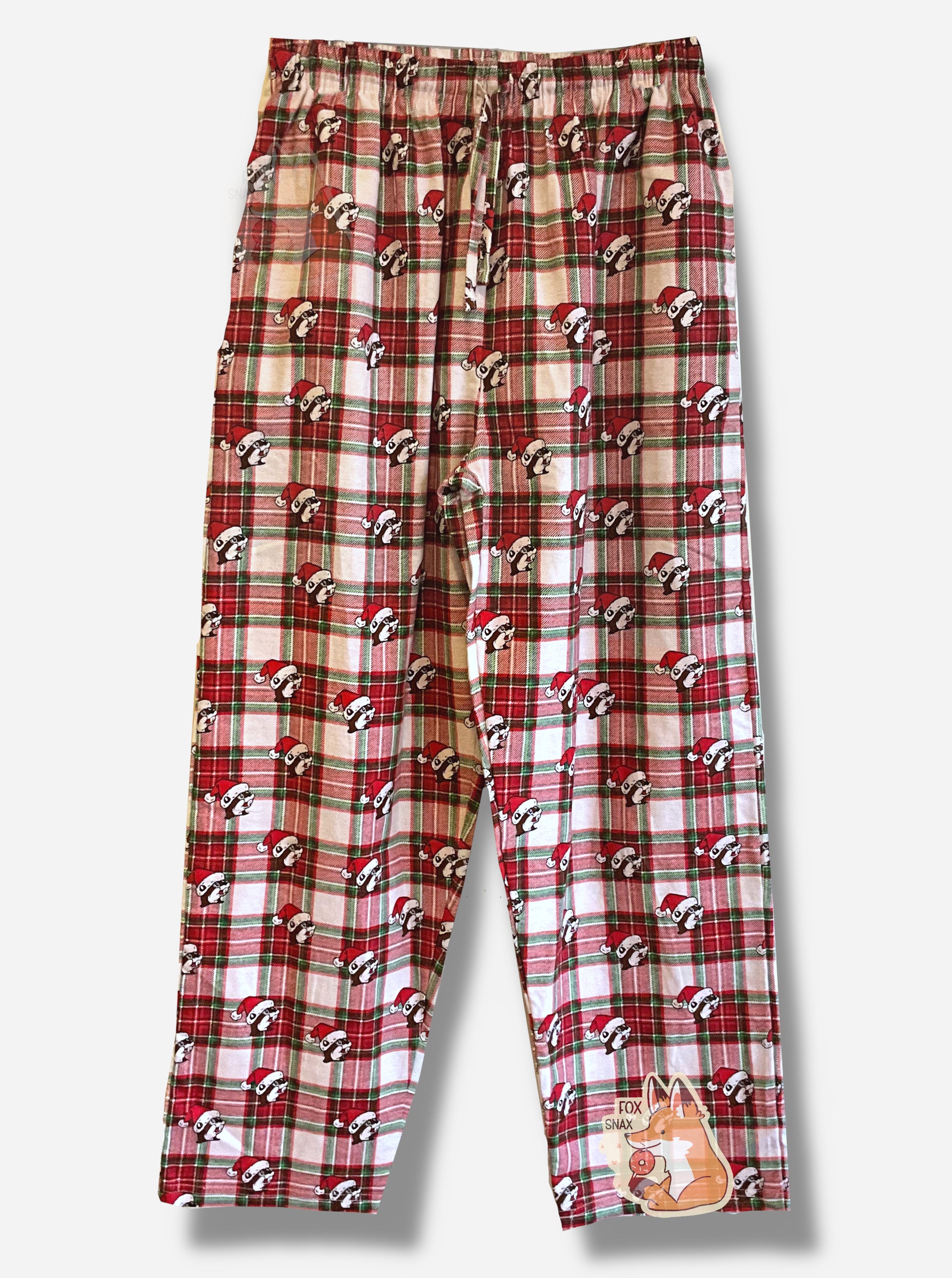 A picture of a plaid pair of Buc-ee's pajama pants.  The pattern is red, white, and green, and is dotted with Buc-ee the Beaver heads.  Each of the heads is wearing a red Santa hat.  The waist has a drawstring, made of the same material as the pants.