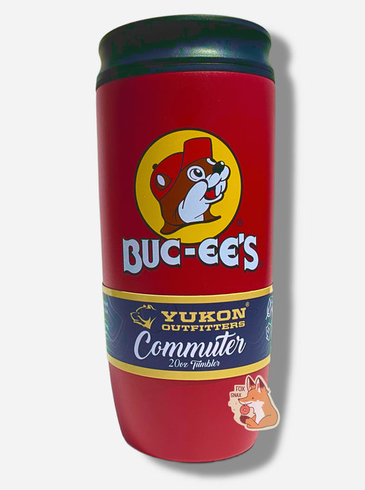 A picture of a medium sized 20oz tumbler, with a giant Buc-ee The Beaver logo on the side; he's framed by a yellow background, and is wearing a red ball cap.  The surface of the cup is red paint over metal.  The top of the cup features a black plastic lid.  The bottom surface is black plastic, and acts as a nice grippy surface so the cup doesn't slide around.