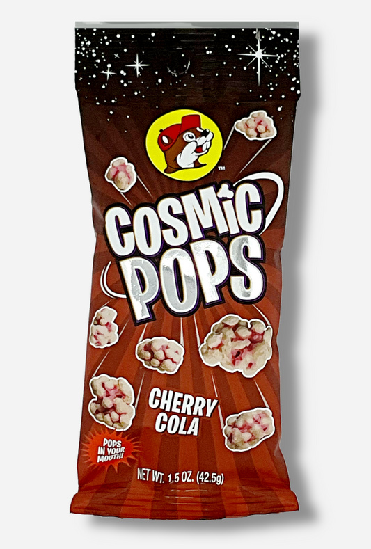 A picture of Buc-ee's Cosmic Pops, in Cherry Cola flavor.  The bag starts with stars against a black background at the top, then shows rays of alternating red colors poking out of the center, to give the impression that the pops - lumpy odd shaped candies - are emerging from the center.  A logo on the bottom reads POPS IN YOUR MOUTH!