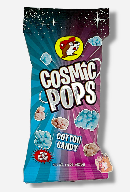 A picture of Buc-ee's Cosmic Pops, in Cotton Candy flavor.  The bag starts with stars against a black background at the top, then shows rays of alternating pink and blue colors poking out of the center, to give the impression that the pops - lumpy odd shaped candies - are emerging from the center.  A logo on the bottom reads POPS IN YOUR MOUTH!