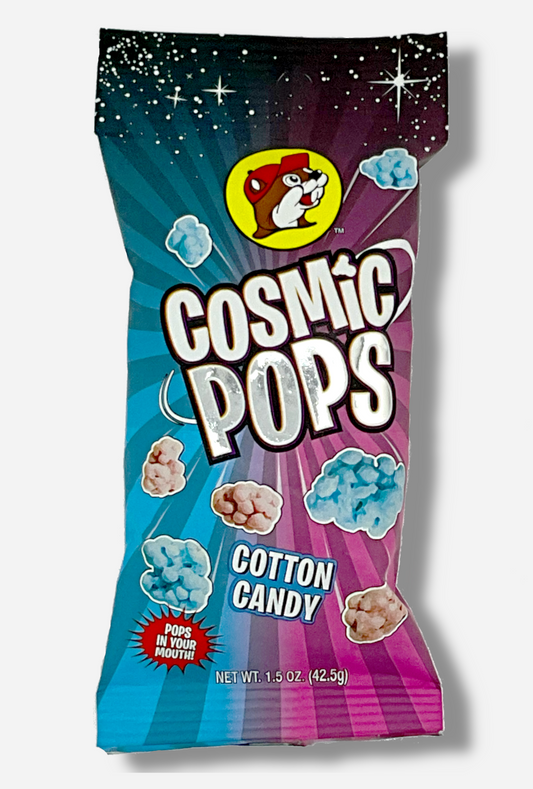 A picture of Buc-ee's Cosmic Pops, in Cotton Candy flavor.  The bag starts with stars against a black background at the top, then shows rays of alternating pink and blue colors poking out of the center, to give the impression that the pops - lumpy odd shaped candies - are emerging from the center.  A logo on the bottom reads POPS IN YOUR MOUTH!
