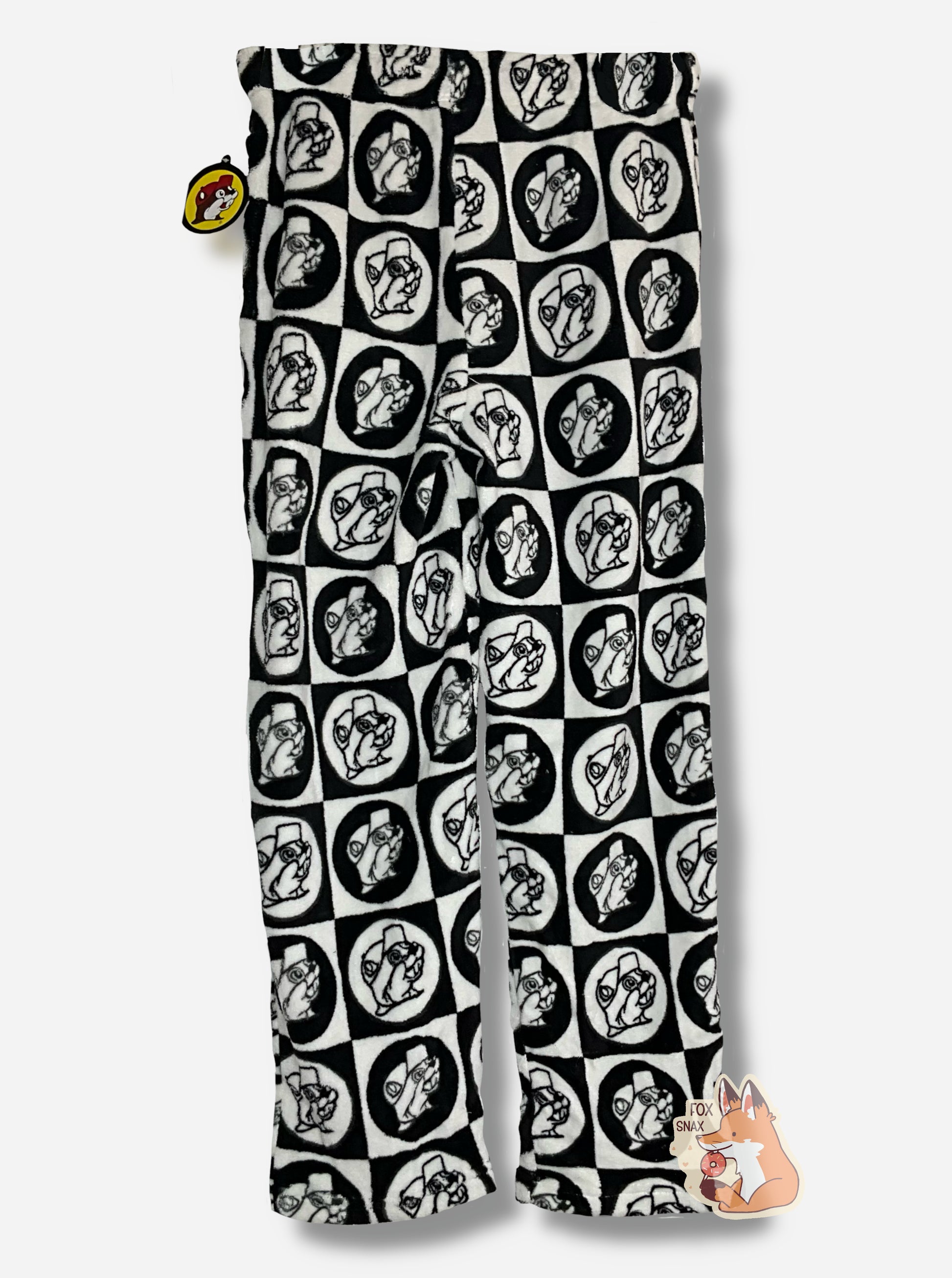 A picture of the back of  a pair of fuzzy lounge pants.  The pants are black and white; the surface has tons of Buc-ee beaver heads on it, checkered alternately in white and black circles and squares. 