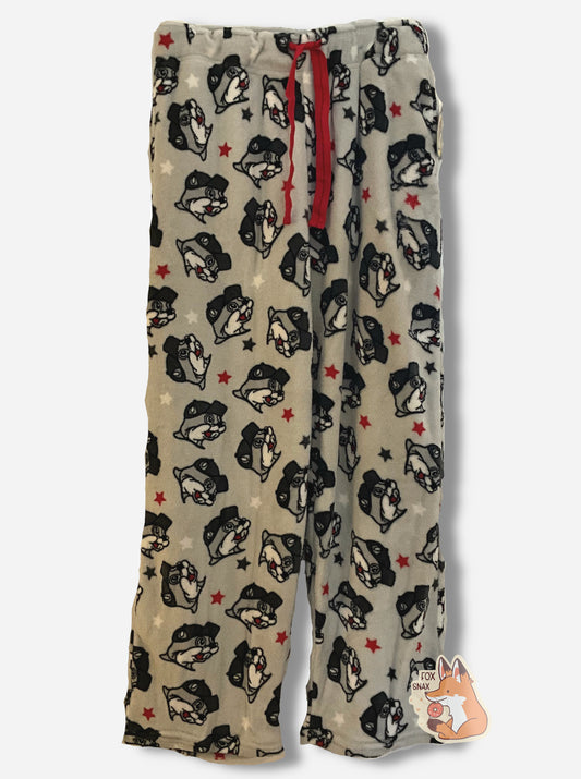 A picture of a pair of fuzzy lounge pants.  The pants are light grey and made of polyester.  The grey surface has tons of Buc-ee beaver heads on it, oriented different directions.  The surface also has red and white stars around the heads.  There is a drawstring to cinch the pants around one's waist, and it is made of a red cloth.  The edges are hemmed.