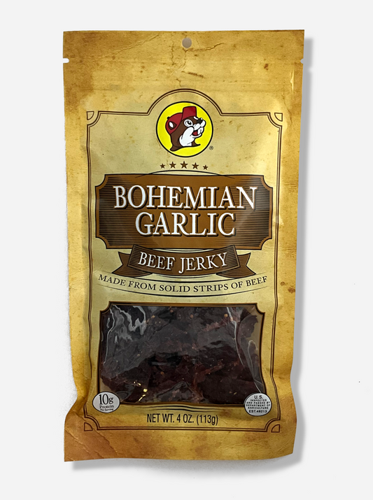 A picture of the front of a tan plastic bag of Buc-ee's Bohemian Garlic Beef Jerky.  The logo is in brown with white text.The label underneath reads 'Made From Solid Strips Of Beef'.A small window on the bottom of the bag shows the dark brown/red dried jerky inside.  The bag has a picture of Buc-ee the Beaver on it.