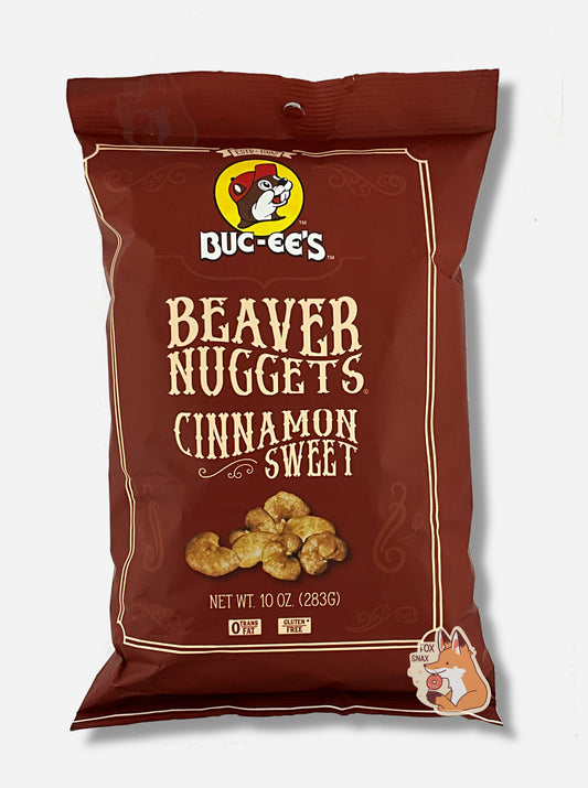 A picture of the front of a opaque, brown bag of Buc-ee's Beaver Nuggets, Cinnamon Sweet.  which are puffed corn snack with cinnamon flavors, and has a picture of Buc-ee the Beaver on it.  The bag reads: 0 Trans Fat.  Gluten Free.