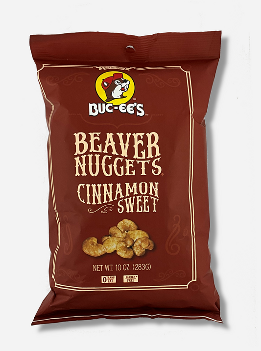 A picture of the front of a opaque, brown bag of Buc-ee's Beaver Nuggets, Cinnamon Sweet.  which are puffed corn snack with cinnamon flavors, and has a picture of Buc-ee the Beaver on it.  The bag reads: 0 Trans Fat.  Gluten Free.