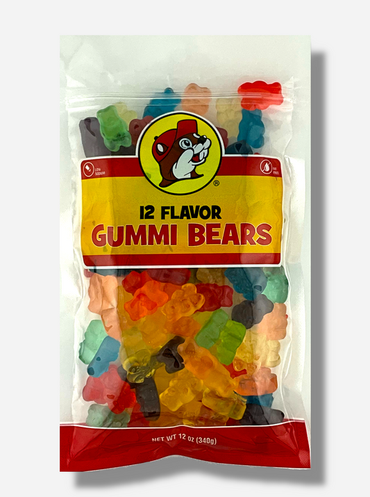 A picture of the front of a resealable bag of Buc-ee's 12 Flavor Gummi Bears, which are brightly colored gummi bears in twelve different flavors.  The bag reads 12 FLAVOR GUMMI BEARS, Low Sodium, Fat Free, and has a picture of Buc-ee the Beaver on it. The bears inside are bear-shaped, and are multiple shades of red, orange, yellow, green, blue, and purple.