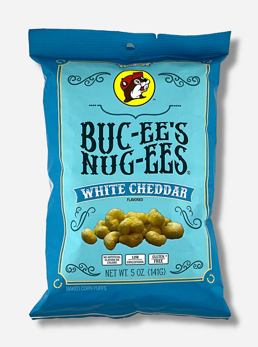 A picture of the front of a opaque, dark blue and light blue bag of Buc-ee's Nug-ees White Cheddar which are puffed corn snack with white cheddar flavor, and has a picture of Buc-ee the Beaver on it.  The bag reads White Cheddar Flavored, No Artificial Colors or Flavors, Low Cholesterol, Gluten Free, Baked Corn Puffs.