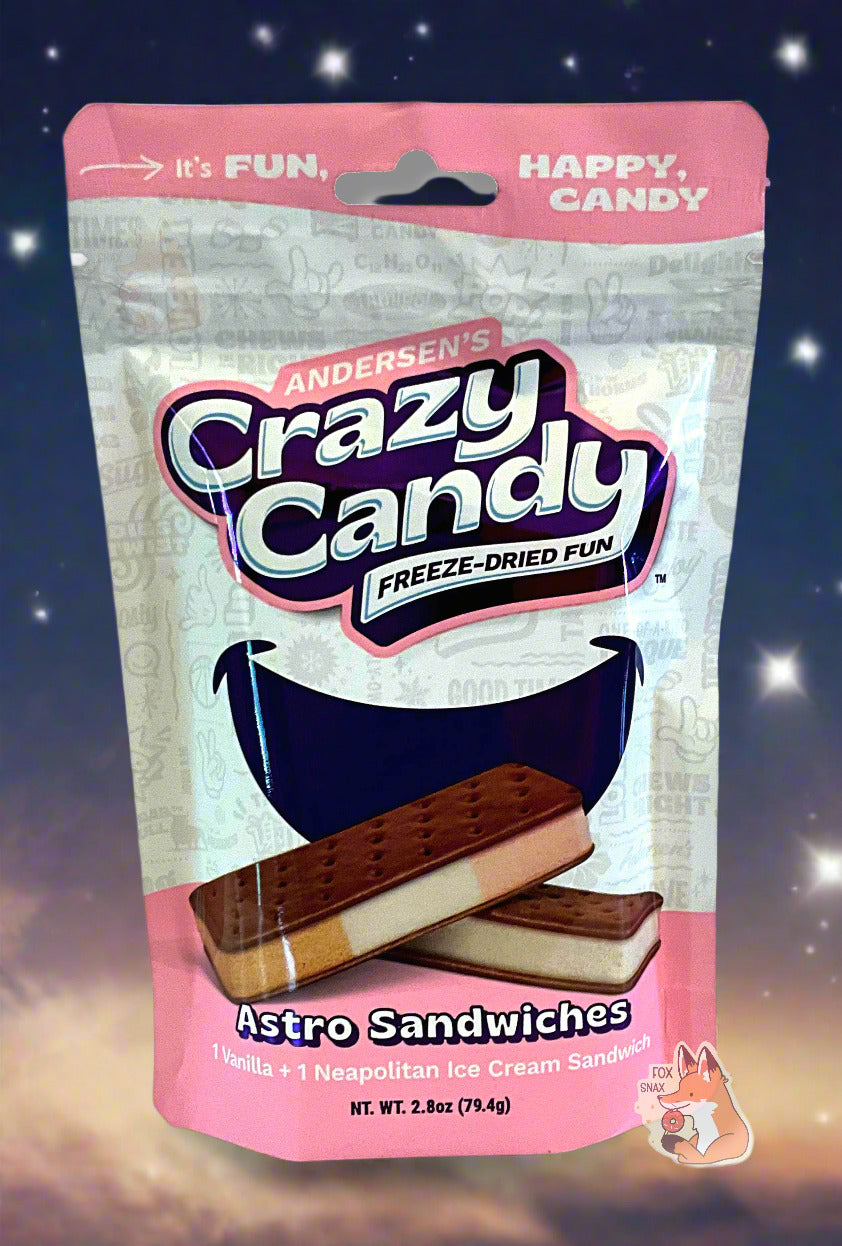 A large bag of Andersen's Astro Sandwiches.  The front of the bag also says Astro Sandwiches, 1 Vanilla + 1 Neapolitan Ice Cream Sandwich, Net Weight 2.8 oz.  It's Fun, Happy, Candy.  The top and bottom of the bag are pink, and the background is a large purple smile against a white background.  The background behind the bag shows a night sky with many white stars; a red/orange comet's tail is at the bottom of the screen.