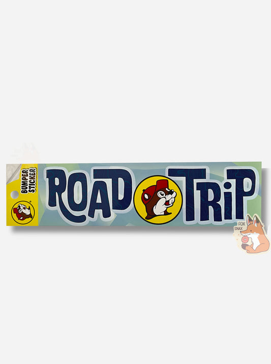A picture of a blue/green bumper sticker that says ROADTRIP.  In between the words ROAD and TRIP is the circular Buc-ee's logo.  The background is a series of light blue and green wavy shapes and the letters are dark blue, surrounded in white.  The font is a print font, not a cursive one, but is sorta wavy and capitalized oddly.