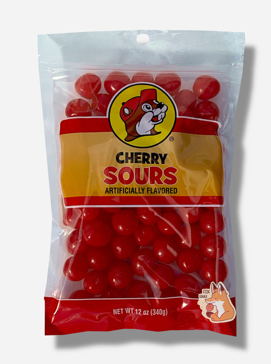 A picture of the front of a resealable bag of Buc-ee's Cherry Sours, which are red sour and sweet cherry candies.  The bag reads CHERRY SOURS, Artificially Flavored, and has a picture of Buc-ee the Beaver on it.  The sours inside are bright red and spherical.