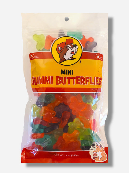 A picture of the front of a resealable bag of Buc-ee's Mini Gummi Butterflies, which are brightly colored gummi butterflies in different flavors.  The bag reads MINI GUMMI BUTTERFLIES, Low Sodium, Fat Free, and has a picture of Buc-ee the Beaver on it. The butterflies inside are buttlerfly-shaped, and are multiple shades of red, orange, green, blue, and purple.