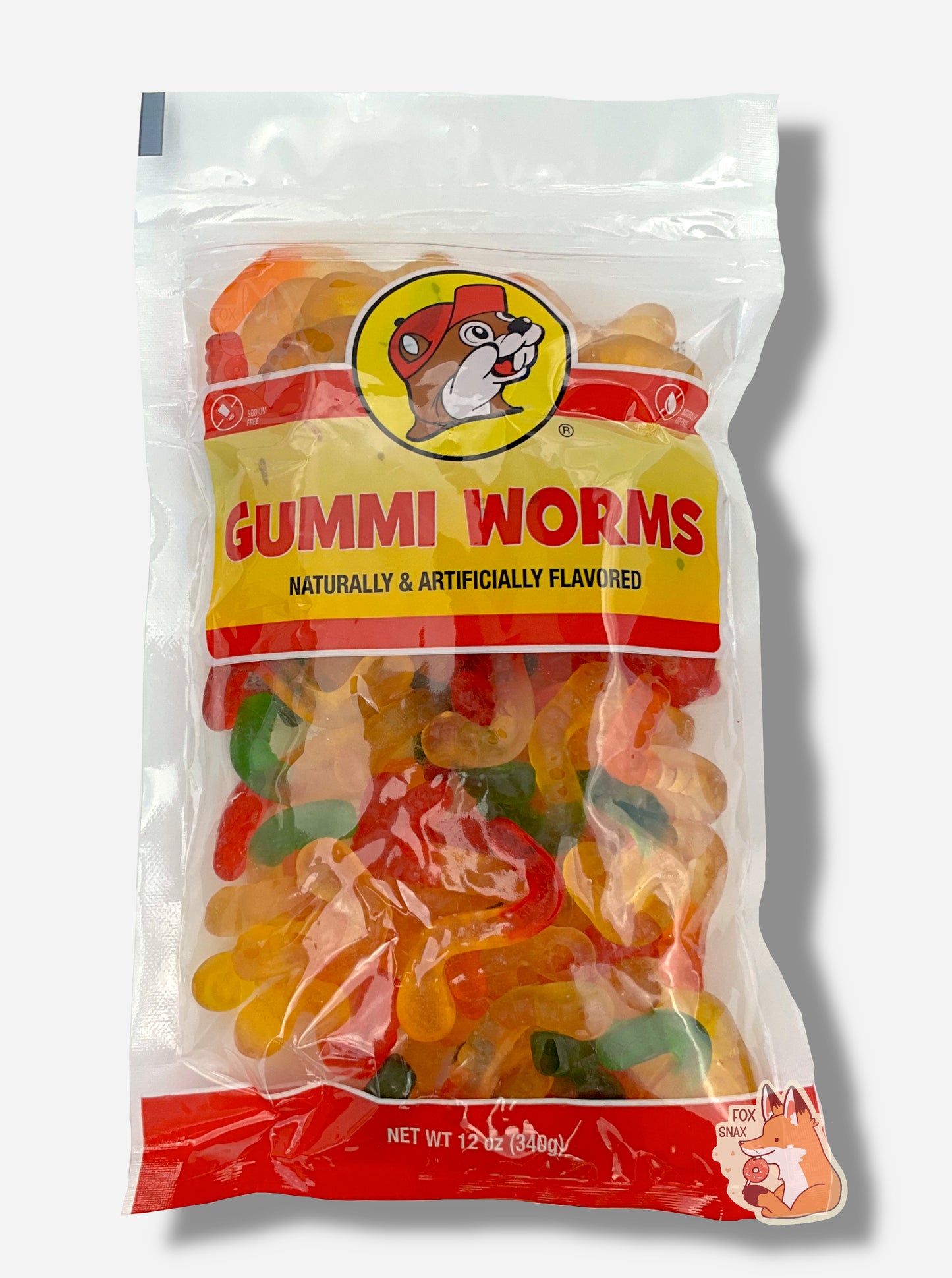 A picture of the front of a resealable bag of Buc-ee's Gummi Worms, which are brightly colored gummi worms in several different bright colors. The bag reads GUMMI WORMS, Naturally & Artificially Flavored, and has a picture of Buc-ee the Beaver on it. The worms inside are multicolored - red-yellow, orange-yellow, and green-yellow.