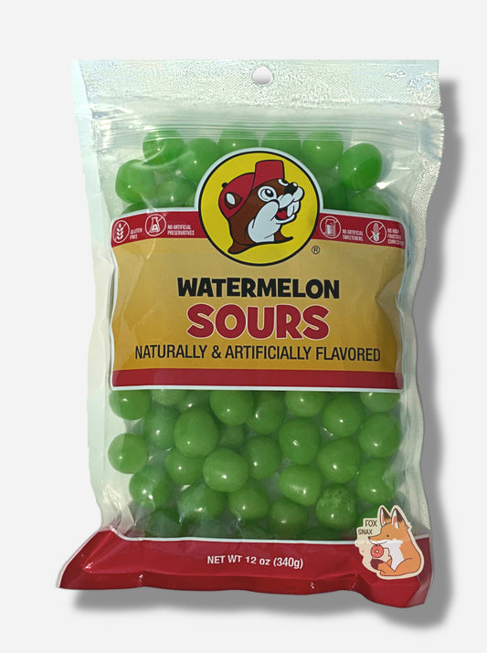A picture of the front of a resealable bag of Buc-ee's Watermelon Sours, which are green sour and sweet watermelon candies.  The bag reads WATERMELON SOURS, Naturally & Artificially Flavored, and has a picture of Buc-ee the Beaver on it.  The sours inside are bright green and spherical.