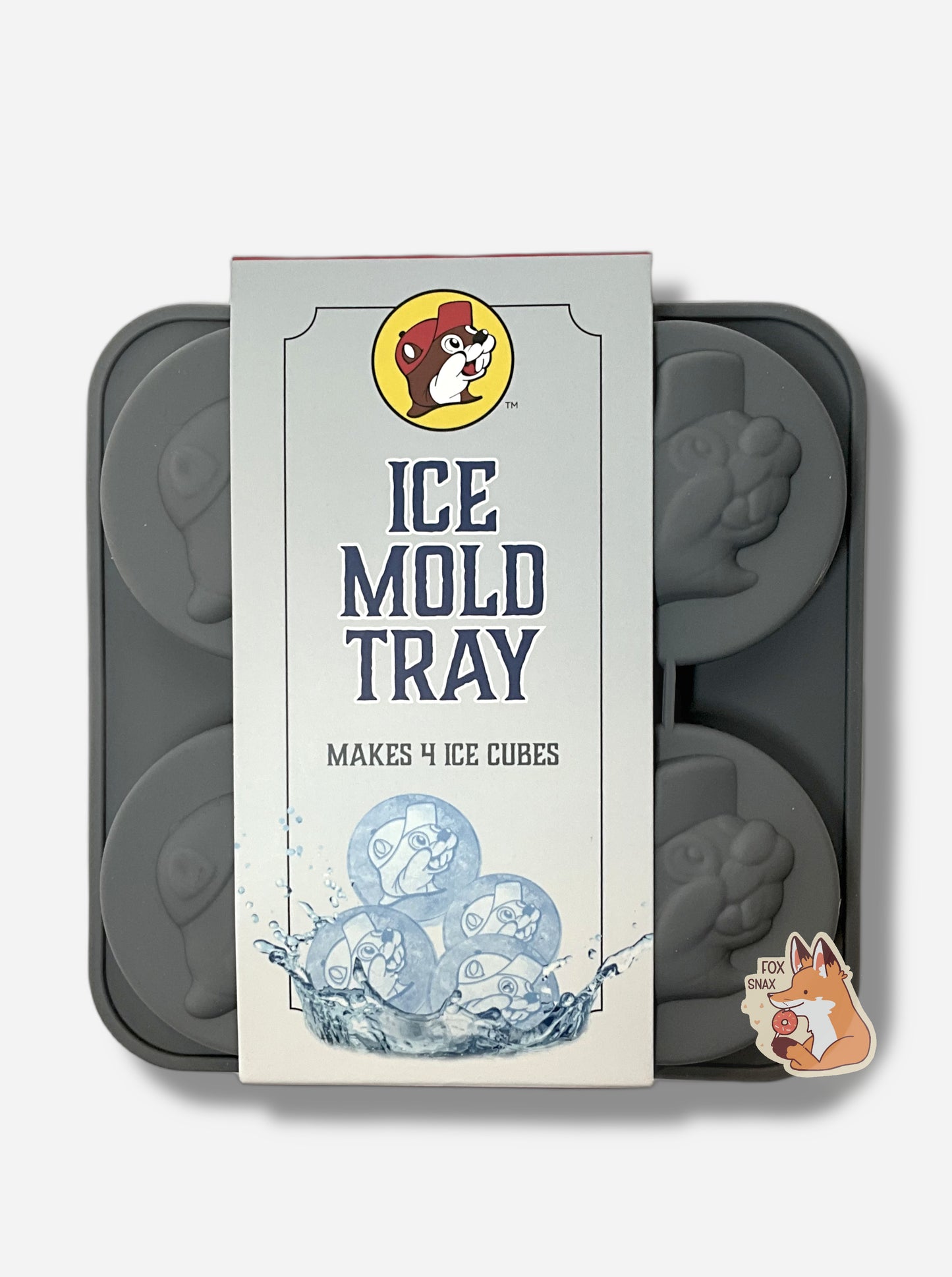 A picture of a grey,  floppy, ice mold tray  The tray is divided into four sections.  Each section contains a large circular imprint, shaped like the Buc-ee's icon - featuring Buc-ee The Beaver's Head, and has the icon with a cheerful grin, ballcap, and buck teeth.  The tag attached to the tray reads ICE MOLD TRAY, MAKES 4 ICE CUBES