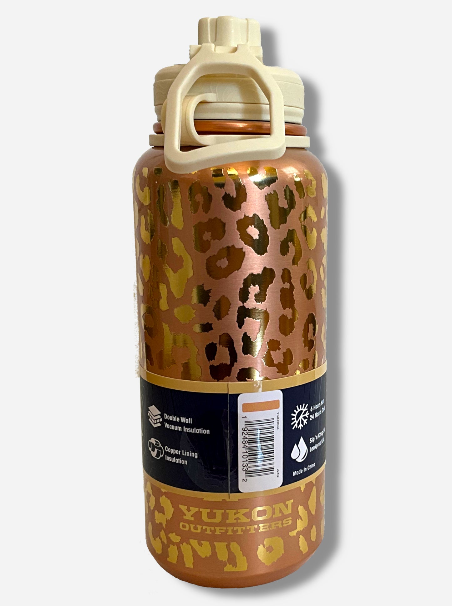 A picture of a tall, metallic, gold leopard print cylindrical water bottle.  The surface is spotted like a leopard's hide, alternately dull and bright gold, as it is covering stainless steel.  There is no handle.  The top is a screw on plastic knob with a keychain handle.  Underneath the paper label, engraved text on the bottom reads: YUKON OUTFITTERS.