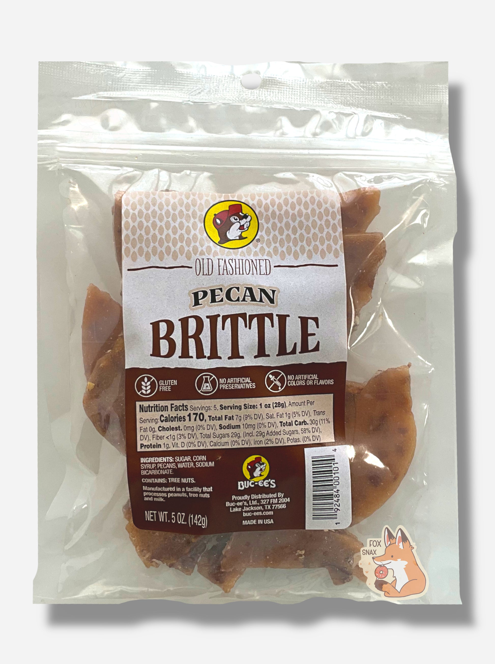 A picture of a square clear plastic bag of Buc-ee's Old Fashioned Pecan Brittle.  The bag has a red and brown rectangular sticker on it, and reads Old Fashioned Pecan Brittle, Gluten Free, No Artificial Preservatives, No Artificial Colors and Flavors.  Inside the plastic bag are brownish irregular pieces of  intermittently dotted with pieces of pecan.