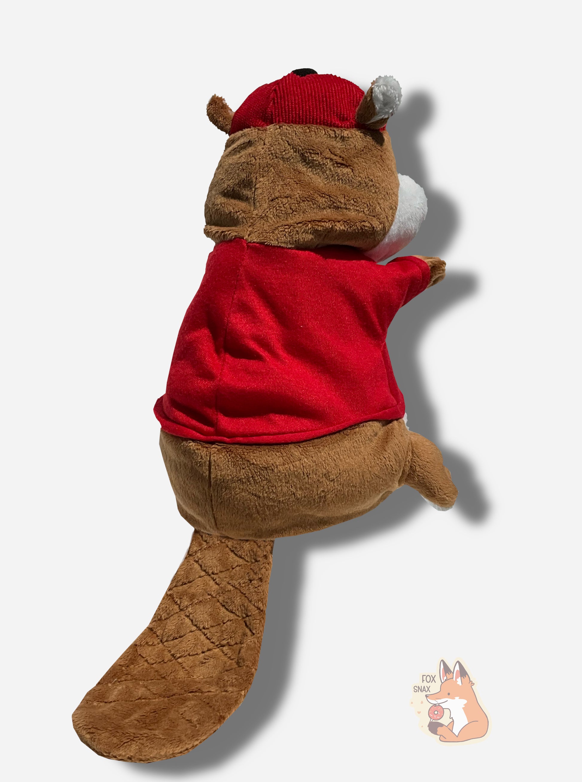 The back of a Buc-ee the Beaver hand puppet.  Buc-ee is covered in brown and white fur, and has a big buck-tooth grin.  On his head is a red ball cap, and he's wearing a red t-shirt with the Buc-ee's logo.  Buc-ee's has a large brown beaver tail poking from his backside.